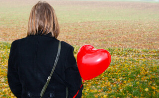 Γυναίκα κρατά ένα μπαλόνι καρδιά