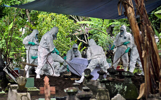 Άνδρες σε νεκροταφείο covid στην Ινδονησία