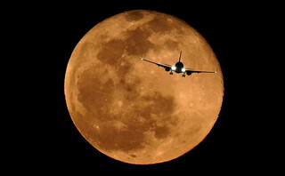 Ένα αεροπλάνο με φόντο το φεγγάρι