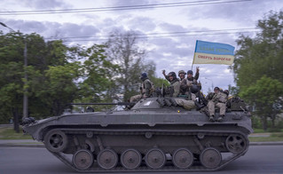 Ουκρανοί στρατιώτες με σημαία που γράφει "Δόξα στην Ουκρανία"